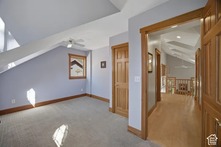 Sloped ceilings, wood-finish trim, ceiling fan, wood-finish doors, and wood-finish flooring