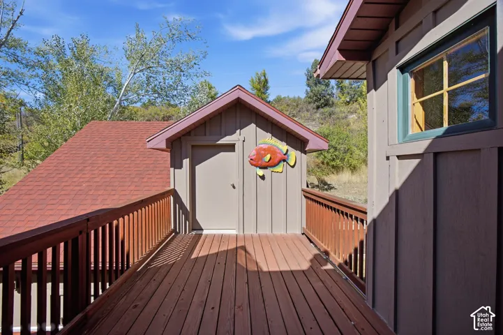Exterior deck with wood-finish flooring, wood railing, and board-and-batten siding