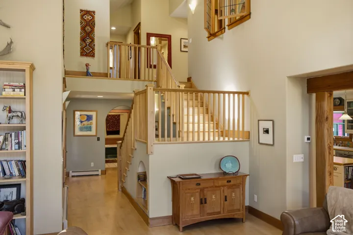 Multi-level interior featuring natural wood staircases, open railings, wood-finish flooring, and arched doorways