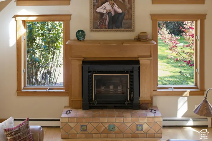Wood-finish fireplace surround with a black metal insert, complemented by a tile hearth featuring patterned accents