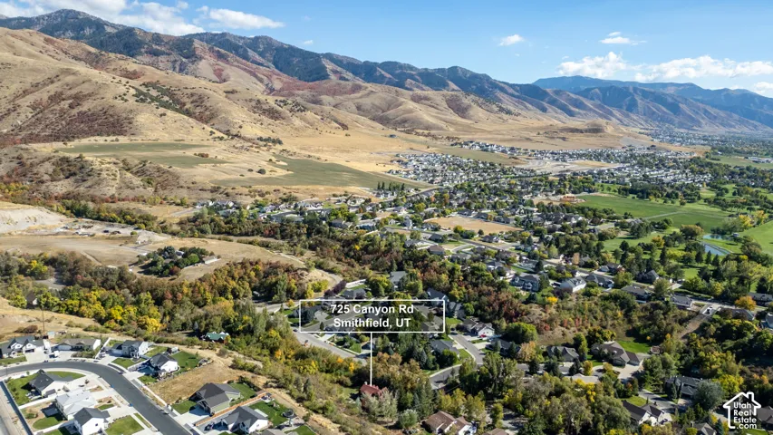 Mountainous terrain backdrop, residential area, extensive green spaces, natural landscape features, winding roads