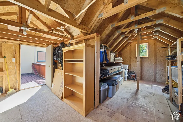 Vaulted wood-beam ceiling, exposed wood framing, wood-finish flooring, and a rectangular window