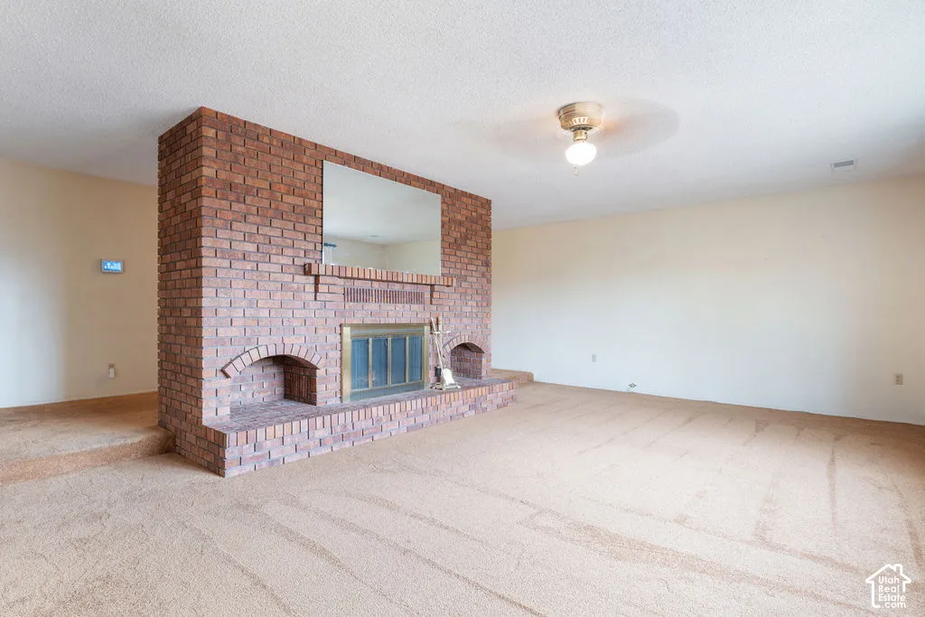 Brick fireplace with brass-framed doors, integrated mirror, and arched storage niches