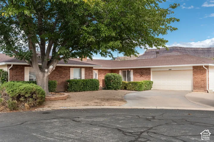 Brick exterior with mature landscaping and an attached two-car garage
