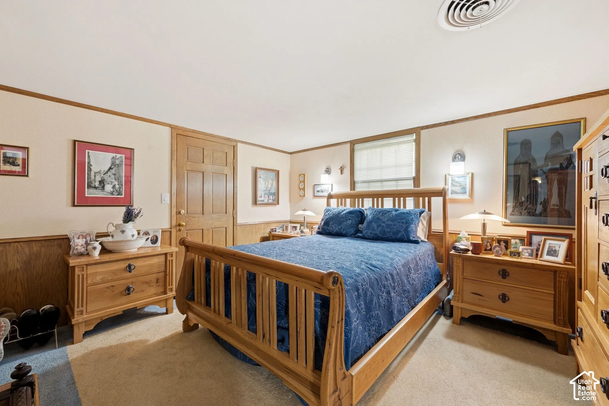 Carpeted flooring, wood paneling, wood trim, white window blinds, and a paneled wood door