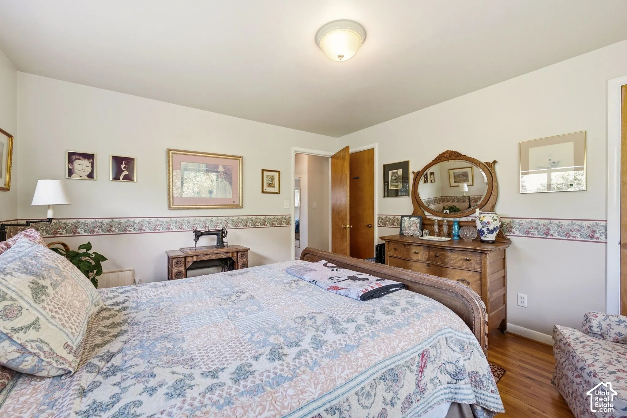 Hardwood flooring, painted walls, and ceiling-mounted light fixture
