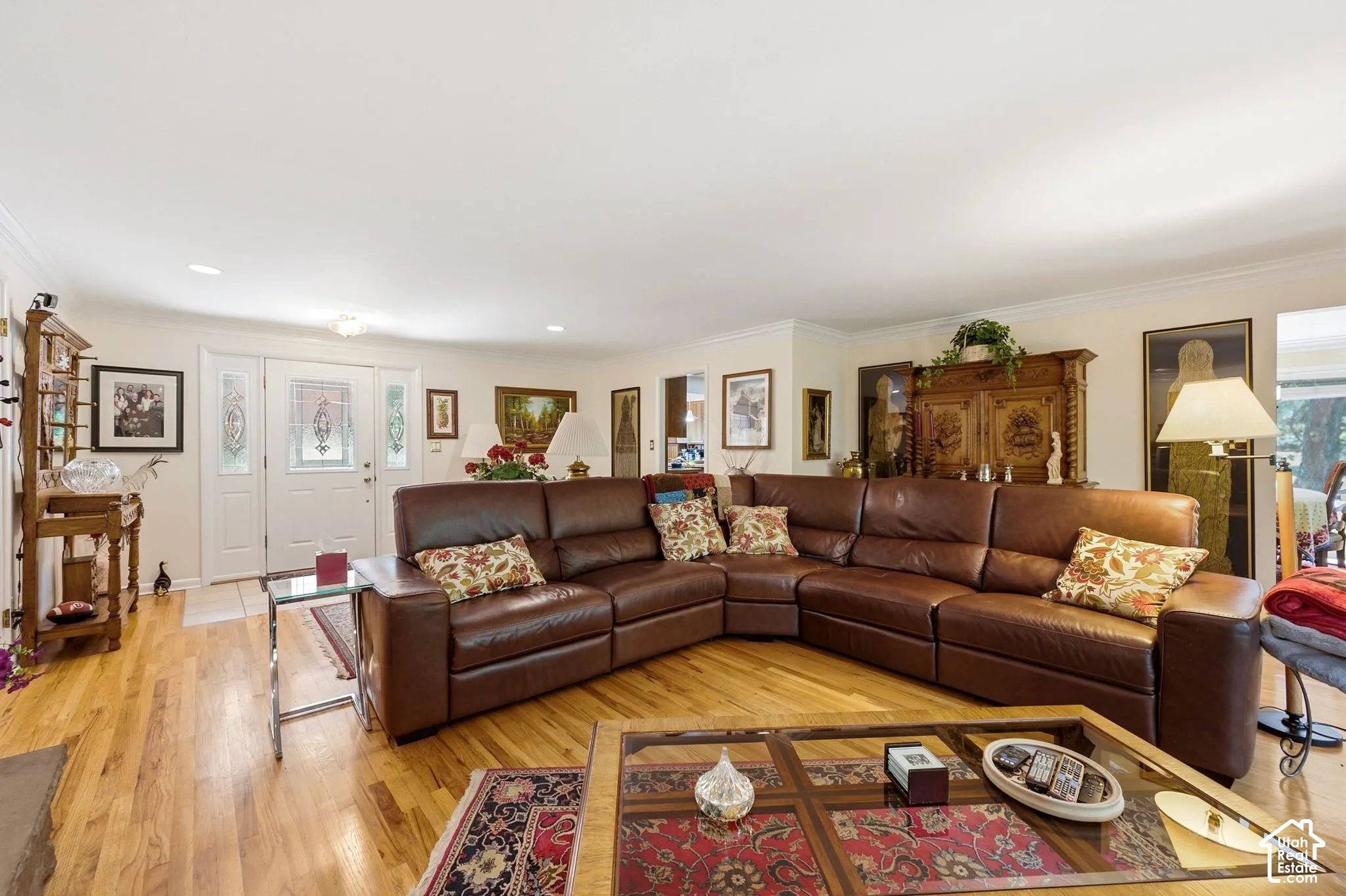 Hardwood flooring throughout, recessed lighting, crown molding, double front entry doors with decorative glass, and a chandelier fixture