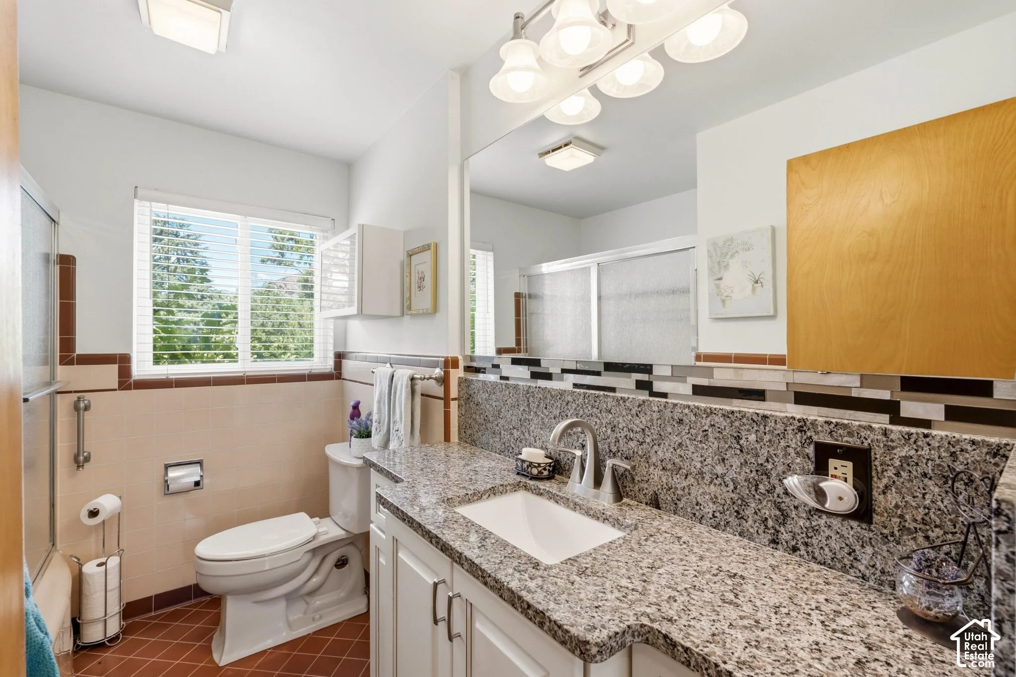 White vanity with a granite countertop, undermount sink, and chrome faucet