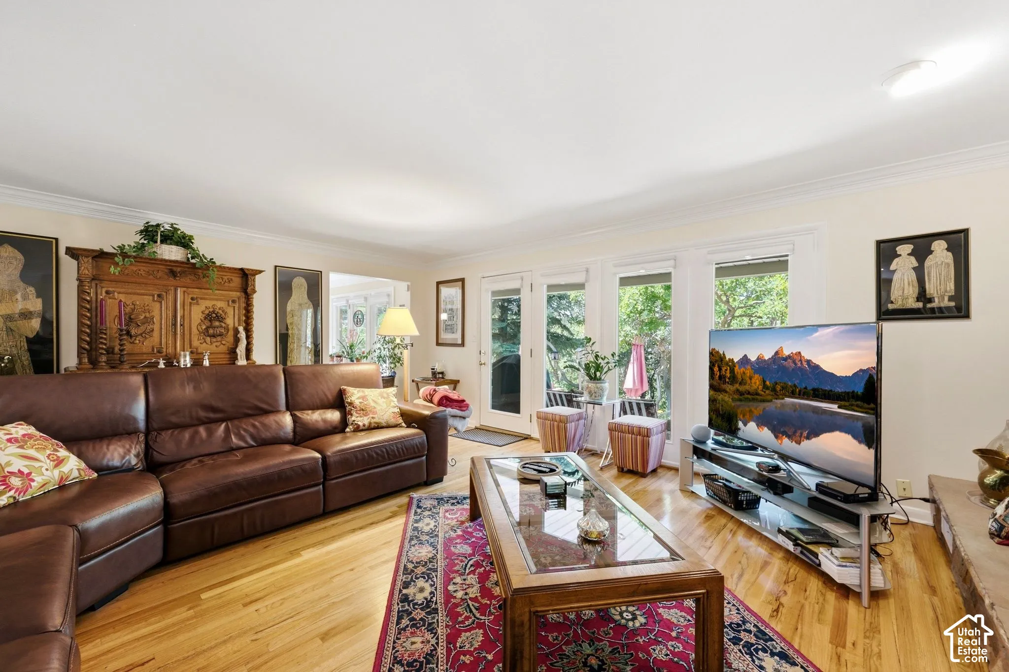 Wood-finish flooring, crown molding, and multiple windows with white trim