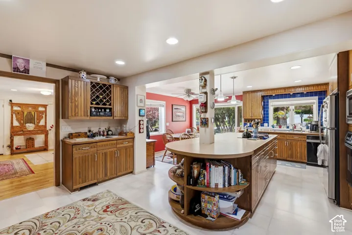 Kitchen featuring a large central island, wood cabinetry, tile flooring, and a built-in wine rack