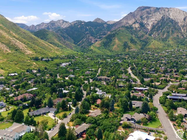Mountainous backdrop with surrounding verdant hillsides, mature trees, and residential streets