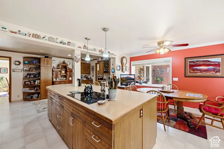 Kitchen featuring a large center island with built-in cooktop, tiled flooring, wood-finish cabinetry, and recessed lighting