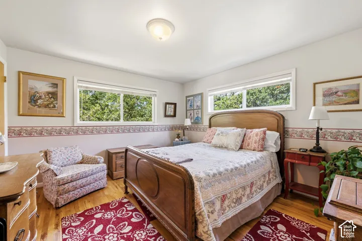 Hardwood flooring, two windows, and a flush-mount ceiling light fixture