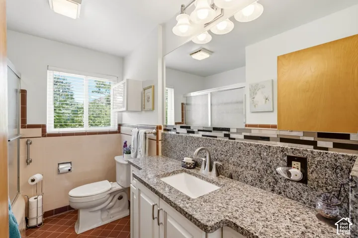 White vanity with a granite countertop, undermount sink, and chrome faucet