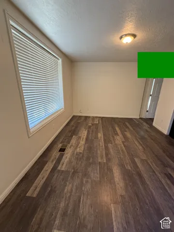 Wood-finish flooring, white trim, recessed lighting, and a large window with blinds