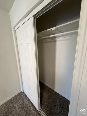 Sliding closet doors with a multi-panel design, integrated shelving, and a clothing rod