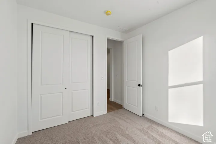 Sliding panel doors, neutral wall tones, and carpeted flooring