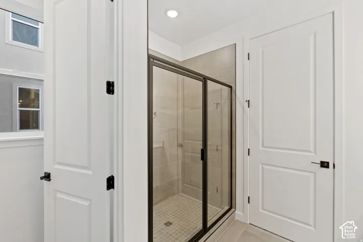 Enclosed shower with clear glass door, large format tile walls, and a tiled shower floor