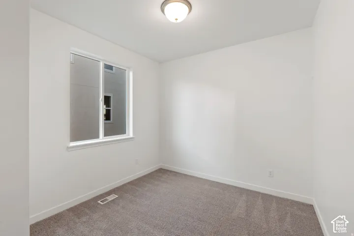 White painted walls with a single window and recessed lighting