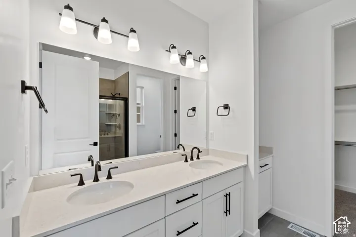 Dual vanity with undermount sinks, white cabinetry, and matte black hardware