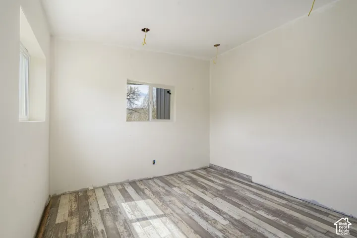 Light-colored walls with two distinct windows and wood-finish flooring