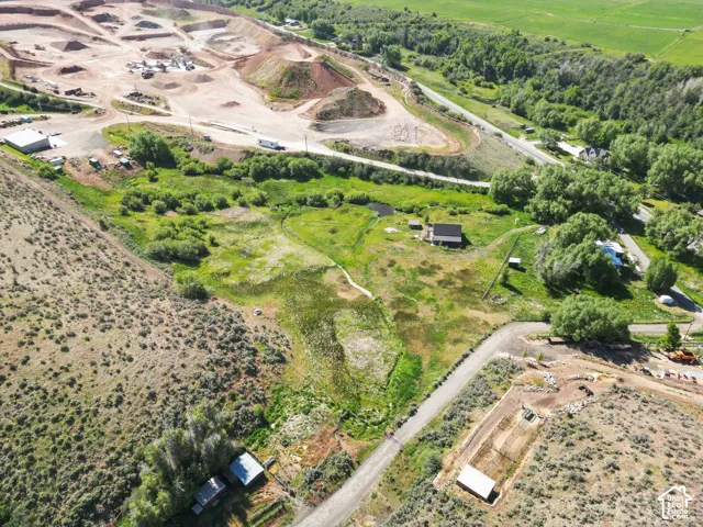 Expansive property featuring a single-story residence, multiple outbuildings, and a gravel road network