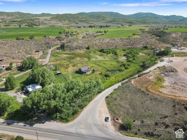 Expansive property featuring varied terrain, a winding road, and mature trees