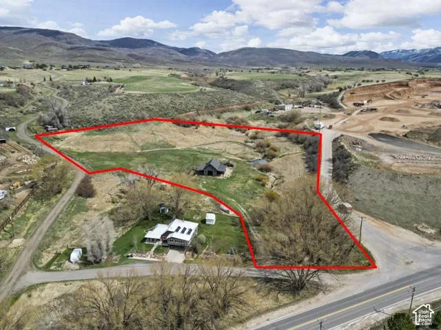Expansive land parcel featuring multiple buildings, direct road access, and varied topography