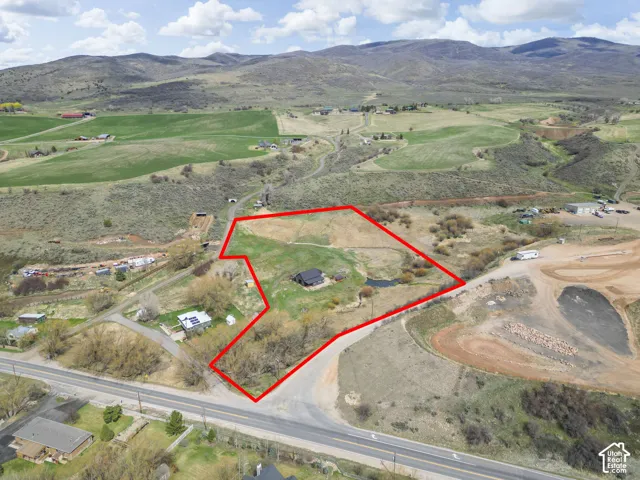 Expansive land parcel featuring a central structure, a water feature, and direct road frontage