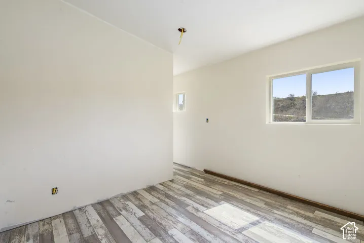 Wood-finish flooring with white walls and natural light from multiple windows