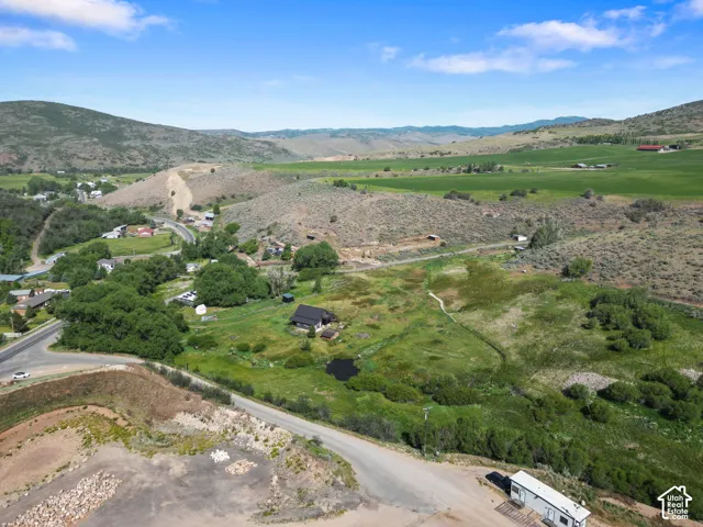 Expansive rural property featuring a natural pond, a winding stream, and abundant mature trees
