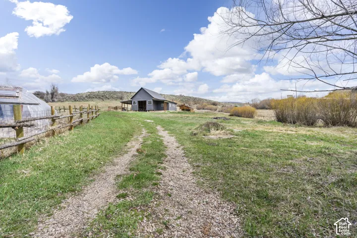 Gravel pathway leading to a barn-style structure with a covered porch