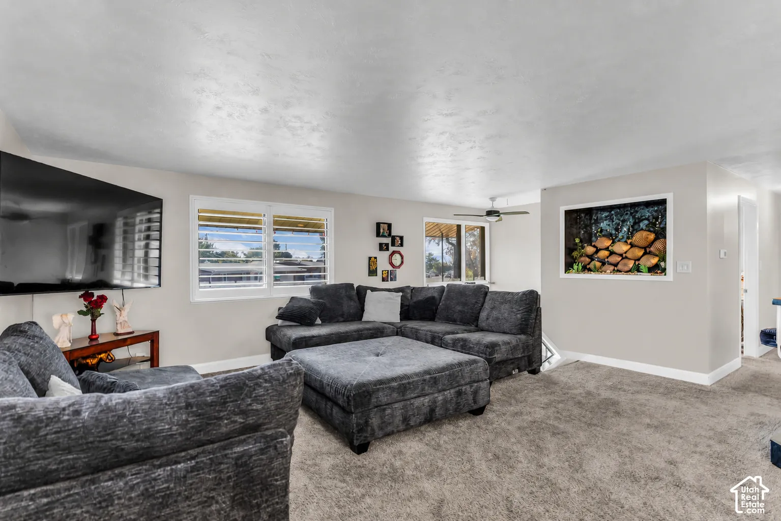 Recessed lighting, ceiling fan, natural light from multiple windows, textured ceiling, and neutral wall tones