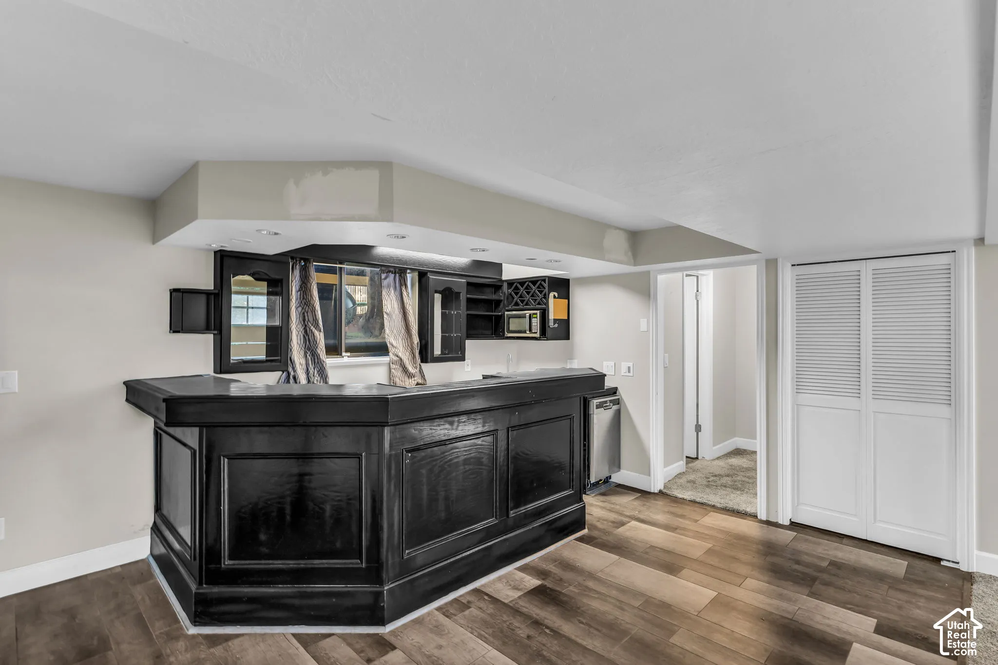 Built-in bar with dark wood-finish cabinetry, integrated shelving, and recessed lighting