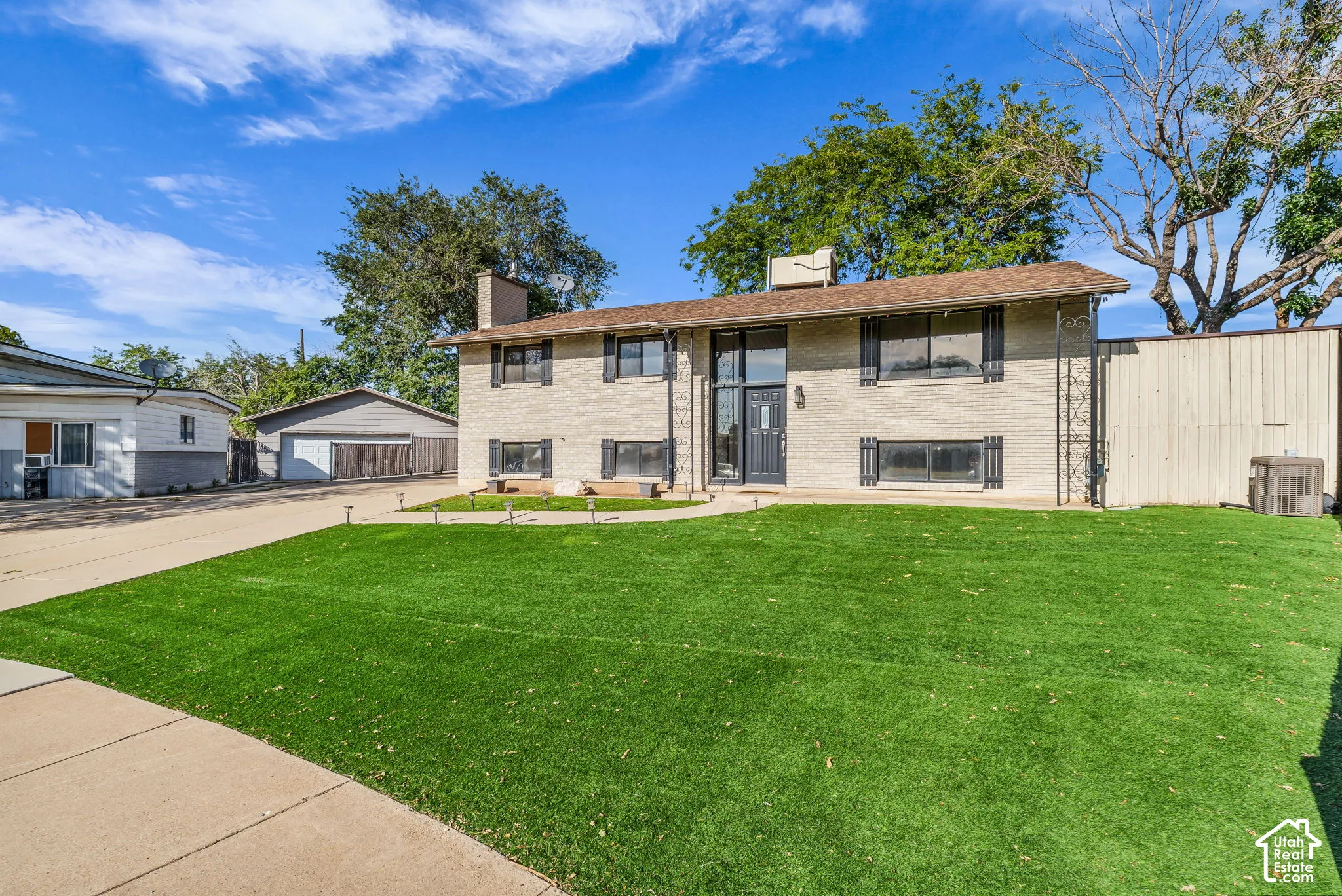 Split-level residence featuring a brick exterior and a dark entry door