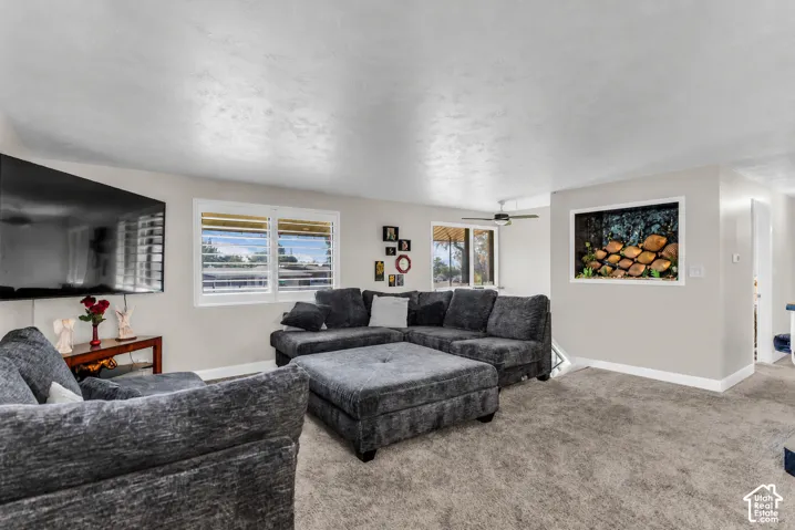 Recessed lighting, ceiling fan, natural light from multiple windows, textured ceiling, and neutral wall tones