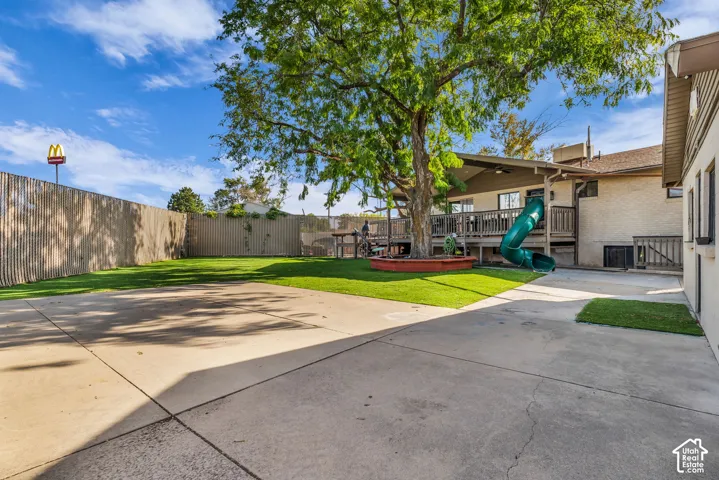 Expansive concrete patio with a lush green lawn