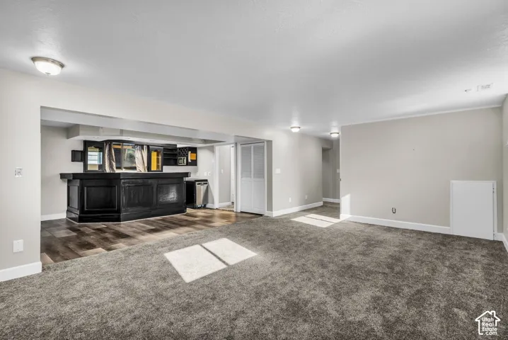Spacious interior with gray carpeting, white baseboards, and neutral wall tones