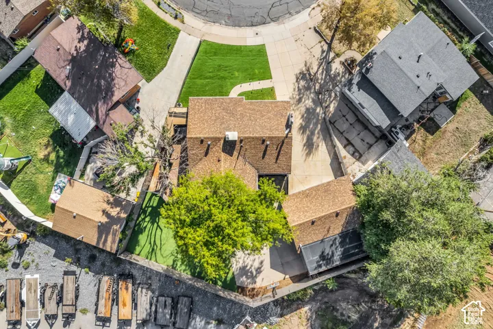 Central property with a brown shingle roof, surrounded by neighboring homes with various roof styles