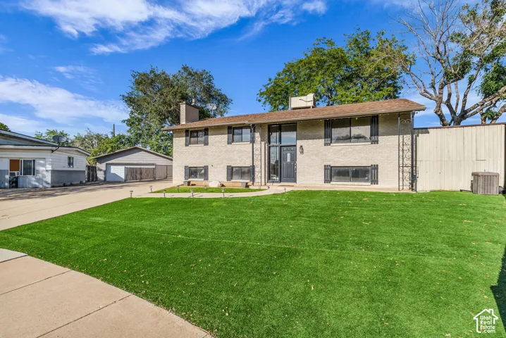 Split-level residence featuring a brick exterior and a dark entry door