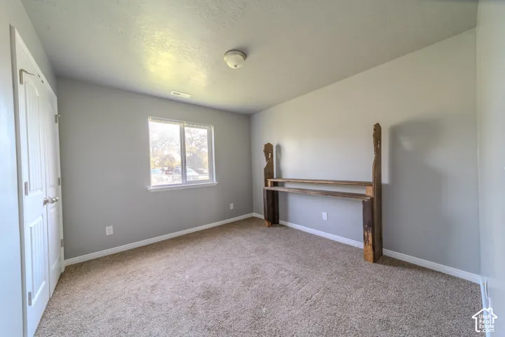 Neutral wall color, wall-to-wall carpeting, recessed window, flush mount ceiling light, and white paneled door