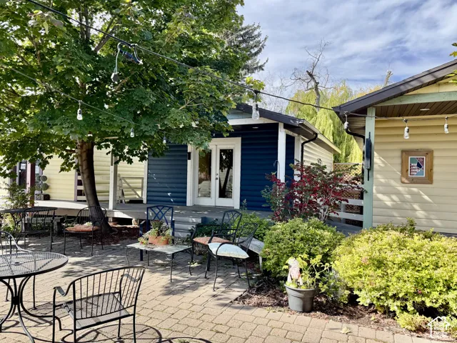 Brick paver patio with mature landscaping and a large shade tree Unit 2
