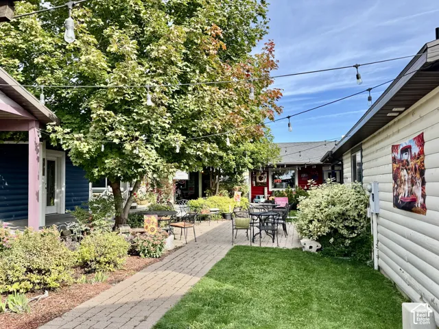 Cobblestone walkway leading to a patio area seating and lush landscaping