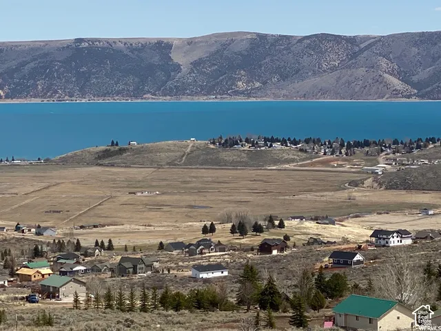Expansive water body, mountainous terrain, and scattered residential properties