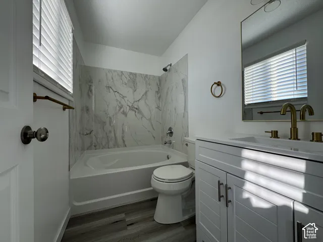 White shaker-style vanity with sleek hardware, gold-tone fixtures, and a rectangular undermount sink