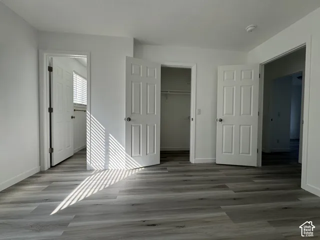 Light-toned wood-finish flooring complements the neutral white walls throughout