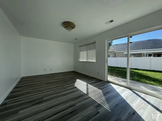 Wood-finish flooring, white walls, and a decorative ceiling fixture