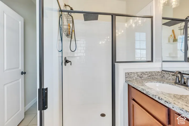 Glass-enclosed shower with subway tile surround, dark bronze fixtures, and a rain showerhead