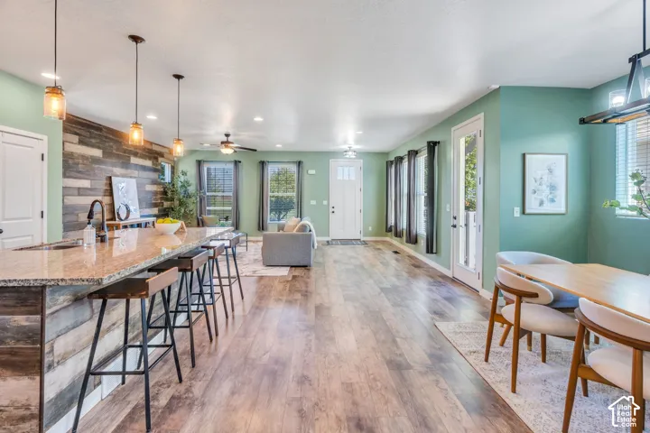 Wood-finish flooring throughout, with a kitchen island featuring a granite-style countertop and wood-paneled base