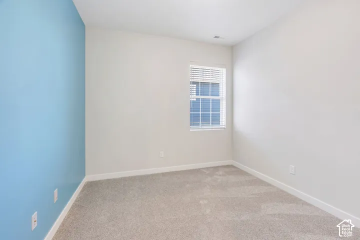 Neutral carpeting and a light blue accent wall